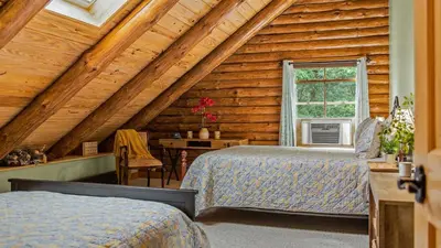 a bedroom with two beds in a log cabin at Bigwood Cabin Near Camelback Skiing Hot Tub Game Room Firepit Yard in Long Pond