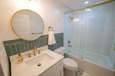 a bathroom with a sink and a mirror and a tub at Prime Location on Main Street in Stroudsburg