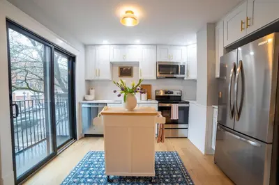a kitchen with white cabinets and a refrigerator at Prime Location on Main Street in Stroudsburg