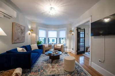 a living room with a blue couch and a table at Apt in the heart of Main Street in Stroudsburg