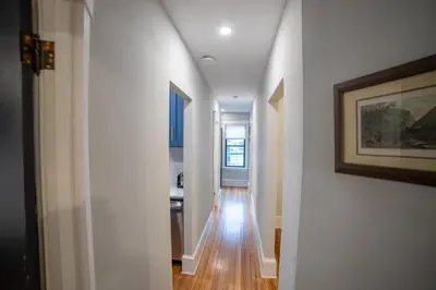 a hallway with white walls and wooden floors in a house at Apt in the heart of Main Street in Stroudsburg