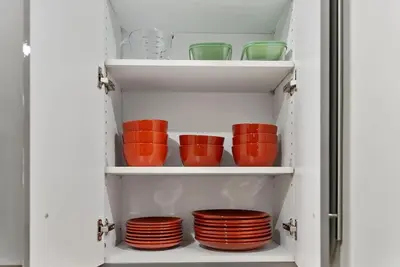 a cabinet filled with red bowls and plates at Beautiful 1BD With Balcony Hosted By StayRafa - 3F in Philadelphia