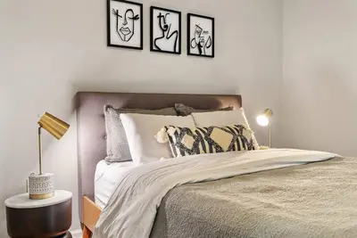 a bedroom with a bed with four pictures on the wall at Beautiful 1BD With Balcony Hosted By StayRafa - 3F in Philadelphia
