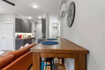 a kitchen with a table and a clock on the wall at Beautiful 1BD With Balcony Hosted By StayRafa - 3F in Philadelphia