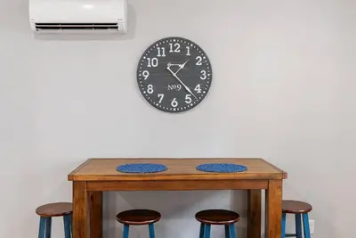 a clock on a wall above a table with stools at Beautiful 1BD With Balcony Hosted By StayRafa - 3F in Philadelphia