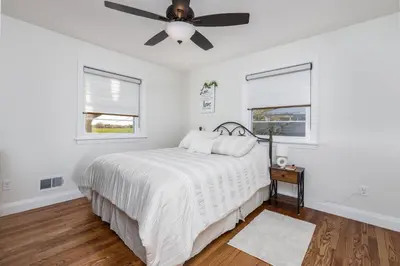 a white bedroom with a bed and a ceiling fan at Backyard Getaway•Amish Farmland•Hot tub•Fire pit in Bird in Hand