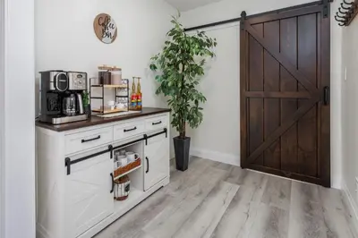 a kitchen with white cabinets and a wooden door at Backyard Getaway•Amish Farmland•Hot tub•Fire pit in Bird in Hand