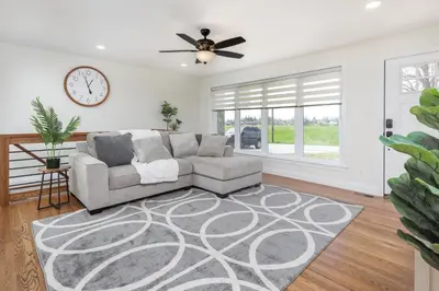 a living room with a couch and a clock on the wall at Backyard Getaway•Amish Farmland•Hot tub•Fire pit in Bird in Hand