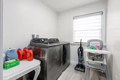 a laundry room with a stove and a chair at Backyard Getaway•Amish Farmland•Hot tub•Fire pit in Bird in Hand