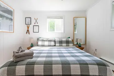 a bedroom with a large bed with a checked blanket at Updated 3 BDR Gas Fire Place BBQ in Albrightsville