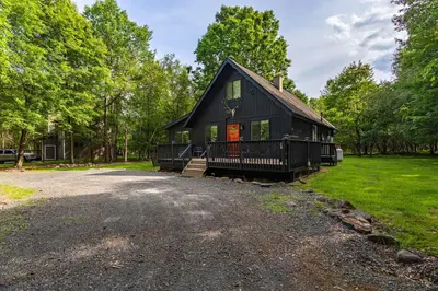 a black house with a porch and a driveway at Updated 3 BDR Gas Fire Place BBQ in Albrightsville
