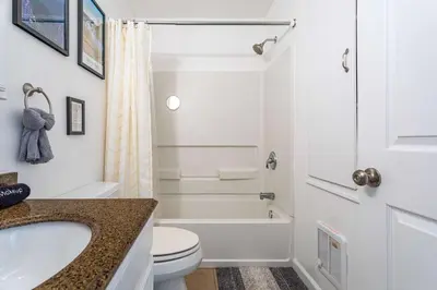 a white bathroom with a toilet and a sink at Updated 3 BDR Gas Fire Place BBQ in Albrightsville