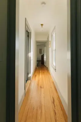 an empty hallway with wooden floors and white walls at Quaint Vintage Reno in Manheim in Manheim
