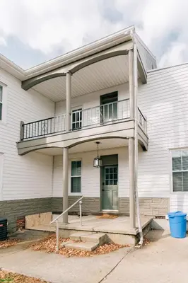 a white house with a balcony on it at Quaint Vintage Reno in Manheim in Manheim