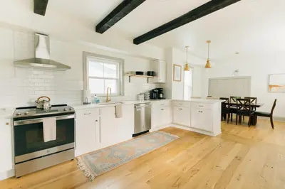 a large kitchen with white cabinets and a wooden floor at Quaint Vintage Reno in Manheim in Manheim