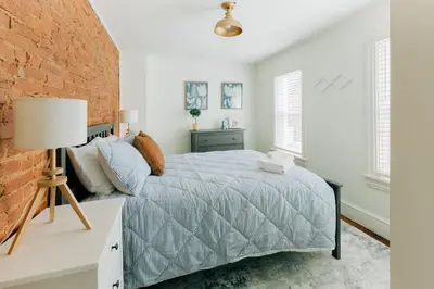 a bedroom with a bed and a brick wall at Getaway on Grant heart of Downtown with parking in Lancaster
