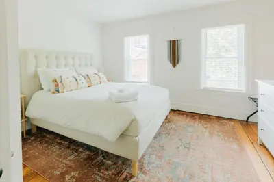 a white bedroom with a large bed and two windows at Getaway on Grant heart of Downtown with parking in Lancaster