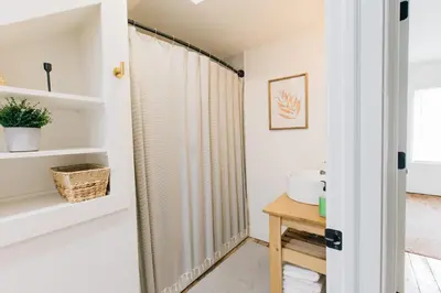a bathroom with white walls and a shower curtain at Getaway on Grant heart of Downtown with parking in Lancaster