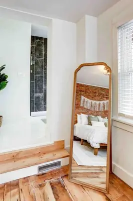 a mirror in a room with a bed and a window at Beautiful Boho Villa on Vine in the heart of Lancaster in Lancaster