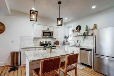 a kitchen with a table and a refrigerator at Beautiful Boho Villa on Vine in the heart of Lancaster in Lancaster