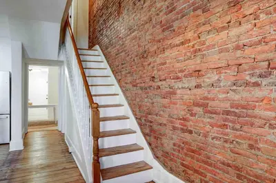 a brick wall with a staircase next to a brick wall at Beautiful Boho Villa on Vine in the heart of Lancaster in Lancaster