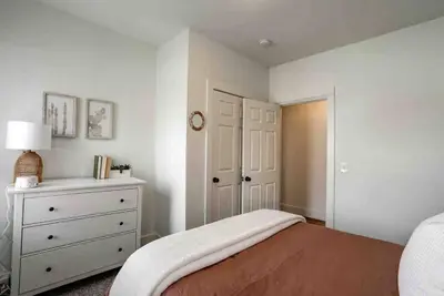 a white bedroom with a bed and a dresser at Beautiful Boho Villa on Vine in the heart of Lancaster in Lancaster
