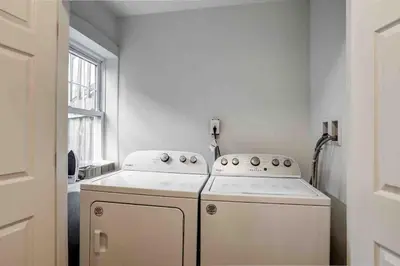 a white kitchen with a stove and a window at Beautiful Boho Villa on Vine in the heart of Lancaster in Lancaster