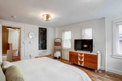 a bedroom with a large bed and a flat screen tv at Beautiful Boho Villa on Vine in the heart of Lancaster in Lancaster