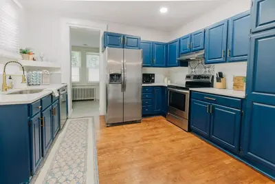 a kitchen with blue cabinets and a stainless steel refrigerator at Comfy renovated townhome - heart of Downtown Lancaster in Lancaster