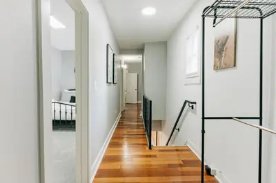 a hallway of a home with white walls and wood floors at Comfy renovated townhome - heart of Downtown Lancaster in Lancaster