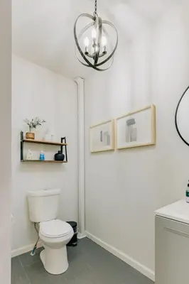 a bathroom with a white toilet and a chandelier at Comfy renovated townhome - heart of Downtown Lancaster in Lancaster
