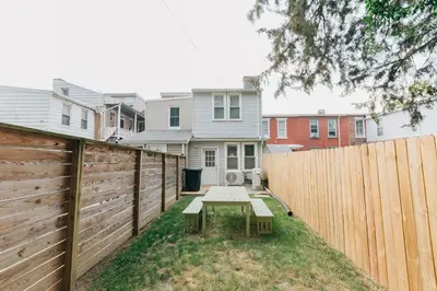 a backyard with a wooden fence and a bench at Comfy renovated townhome - heart of Downtown Lancaster in Lancaster