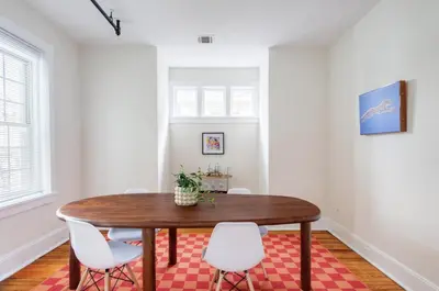 a dining room with a wooden table and white chairs at Fun & Funky 2BR in Downtown Princeton in Princeton