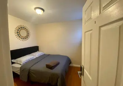 a small bedroom with a bed and a mirror at Historic Townhouse Oasis with En-suite Bathroom in Philadelphia
