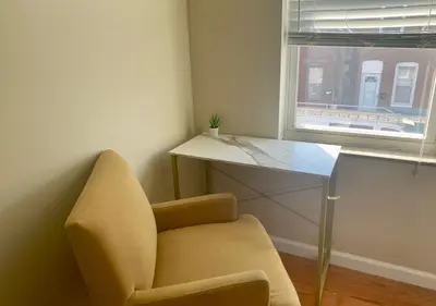 a room with a chair and a desk and a window at Historic Townhouse Oasis with En-suite Bathroom in Philadelphia