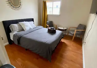 a bedroom with a bed and a chair and a window at Historic Townhouse Oasis with En-suite Bathroom in Philadelphia