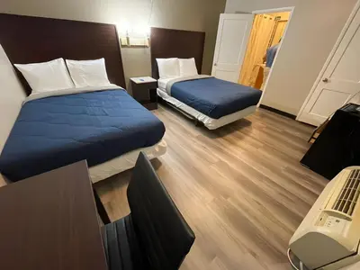 a hotel room with two beds and a desk at Scottish Inns - Middletown in Middletown