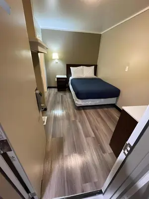 a bedroom with a bed and a wooden floor at Scottish Inns - Middletown in Middletown