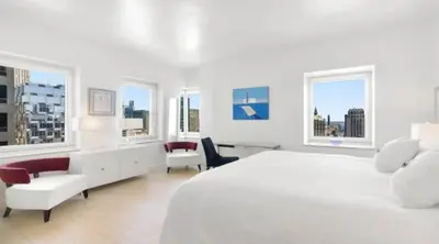 a white bedroom with a large white bed and windows at Exclusive Apartment Midtown Manhattan NYC Luxury Penthouse Sleeps 8 in New York