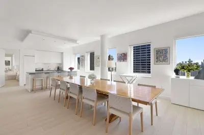 a kitchen and dining room with a wooden table and chairs at Exclusive Apartment Midtown Manhattan NYC Luxury Penthouse Sleeps 8 in New York