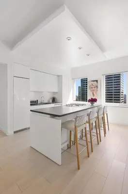 a white kitchen with a table and chairs at Exclusive Apartment Midtown Manhattan NYC Luxury Penthouse Sleeps 8 in New York