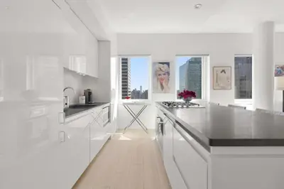 a white kitchen with white counters and windows at Exclusive Apartment Midtown Manhattan NYC Luxury Penthouse Sleeps 8 in New York