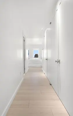 an empty corridor with white walls and a white floor at Exclusive Apartment Midtown Manhattan NYC Luxury Penthouse Sleeps 8 in New York