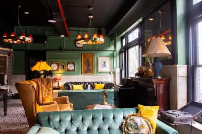 a living room with green walls and a blue couch at The Nolita Express Hostel in New York