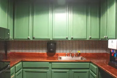 a kitchen with green cabinets and a sink at The Nolita Express Hostel in New York
