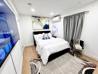 a small bedroom with a bed and a chair at Exquisite 3 Bedrooms in Newark