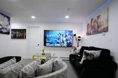 a living room with couches and a flat screen tv at Exquisite 3 Bedrooms in Newark