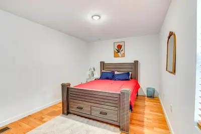 a bedroom with a bed with a red comforter at Modern Elizabeth Apartment about 1 Mi to Train Station in Elizabeth