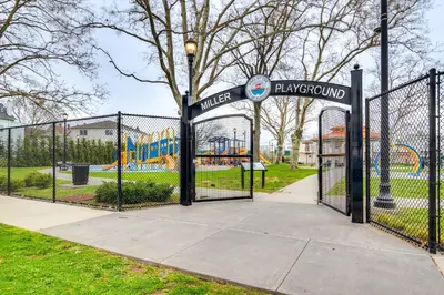 a gate in a park with a playground at Modern Elizabeth Apartment about 1 Mi to Train Station in Elizabeth