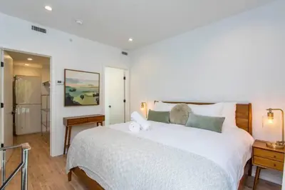 a bedroom with a large white bed and a bathroom at Inventors' Loft - Stay in the Heart of it All in Philadelphia